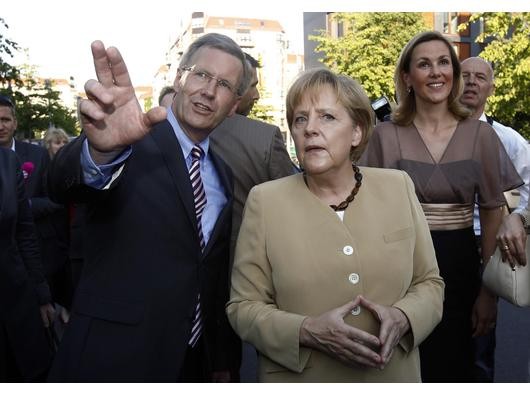...mit Bundeskanzlerin Angela Merkel trug Bettina Wulff ein auf den ersten Blick elegantes, leicht mit Gold abgesetztes Kleid. Auf den zweiten...