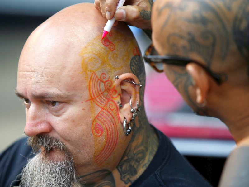 Hier wird noch das geplante Tattoo auf Gesicht und Kopf vorgezeichnet. 