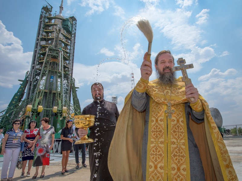 Am 06. Juli 2016 segnet ein orthodoxer Priester in Baikonur (Kasachstan) die Anwesenden nachdem er zuerst die hinter ihm stehende Sojus MS-01-Rakete gesegnet hat. 