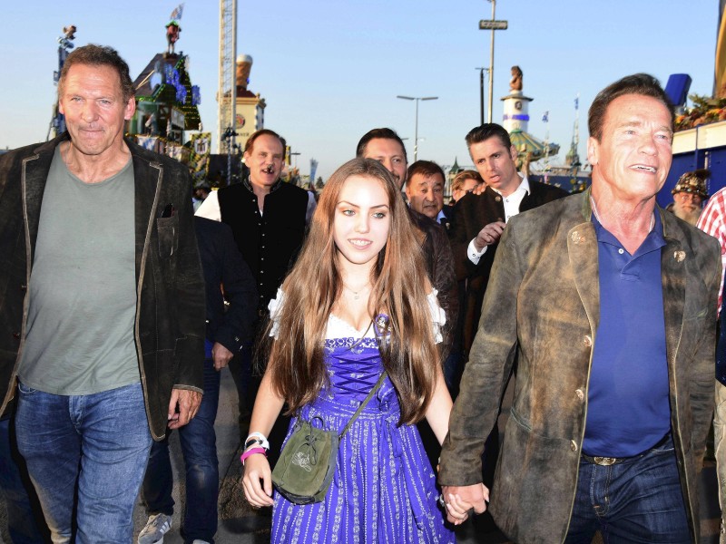Die Muskelpakete und Schauspielkollegen Ralf Moeller (l.) und Arnold Schwarzenegger ließen sich ebenfalls auf der Theresienwiese blicken. Der „Terminator“ zeigte sich Hand in Hand Stella Glaubitz – Tochter von Freunden des Österreichers. So so so.