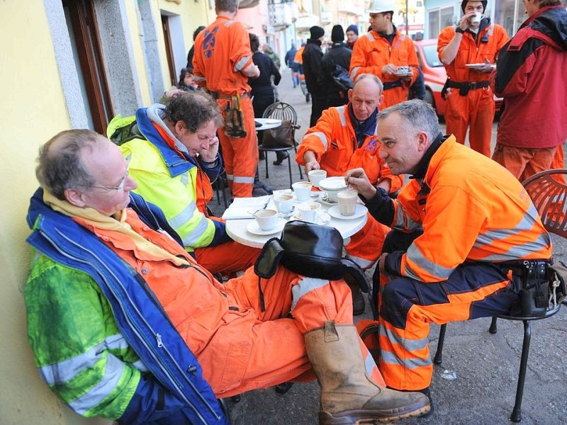 Employees of a wreck removal and salvage operations company take a coffee on January 19, 2012 before working on the cruise liner Costa Concordia aground in front of the harbour of the Isola del Giglio (Giglio island) after hitting underwater rocks on January 13. Italian rescuers resumed their search on board a crashed cruise ship the same day, as salvage workers prepared to pump out fuel from its tanks to avoid an environmental disaster.  AFP PHOTO / VINCENZO PINTO