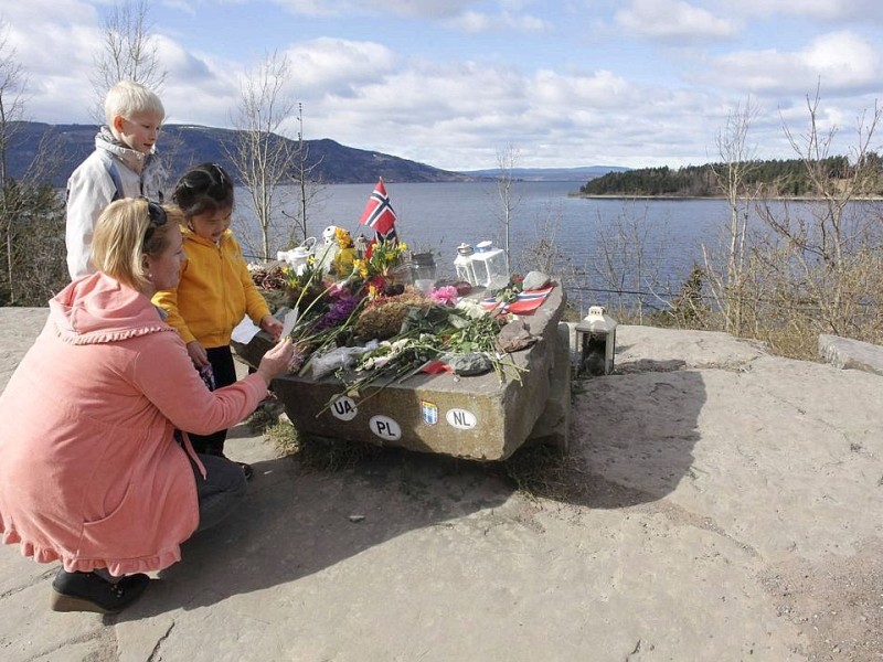 Angehörige legen Blumen nieder und trauern bei Utöya.
