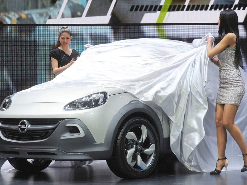 Hübsche Frauen entpacken wieder neue Automodelle: Der 83. Genfer Autosalon hat begonnen. Mit dabei der Opel Adam Rocks.