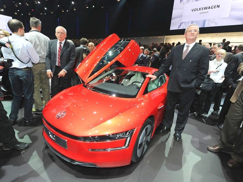 Auch Martin Winterkorn, Vorstandsvorsitzender von VW, posiert neben einem VW XL1 mit Klapptür.