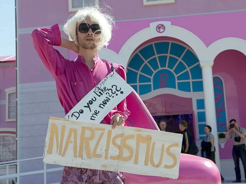 Ganz in pinker Frauenbekleidung und mit Perrücke fragt Protestler Lars auf seinem Schild: Magst du mich jetzt?.