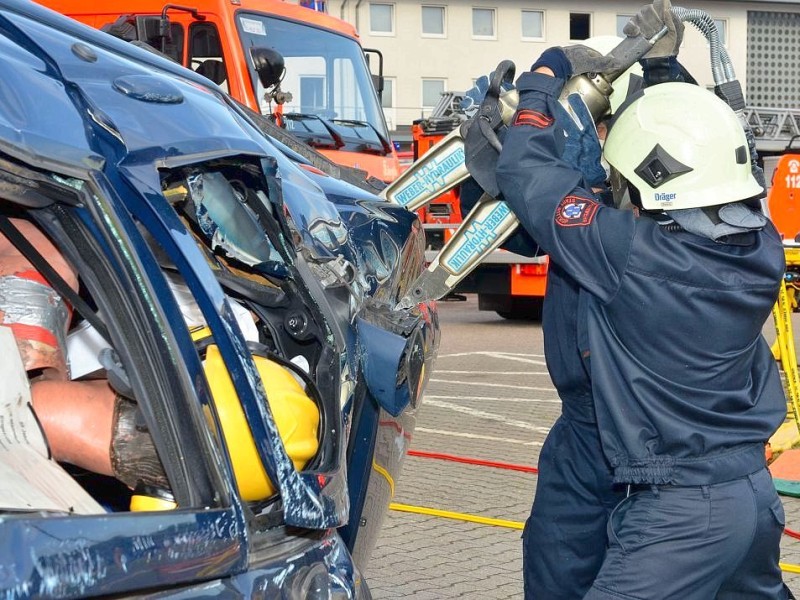 Mit der Hydraulikschere machen sich die Feuerwehrmänner an der Tür zu schaffen.