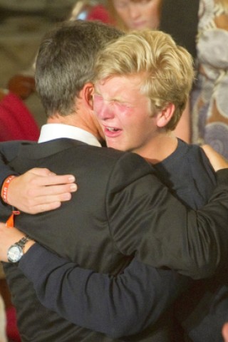 Norwegens Ministerpräsident Jens Stoltenberg nimmt nach dem Gottesdienst einen weinenden Jungen in den Arm.