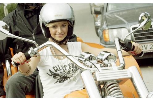 ... setzt sich zugunsten des Kinderschutzbundes in Köln auf ein Motorrad.