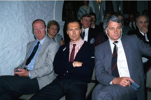 Vor der Fußball-EM 1988 in Deutschland hört Beckenbauer angestrengt zu. Für Englands Teamchef Bobby Robson (re.) und Irlands Coach Jack Charlton (li.) wird übersetzt.