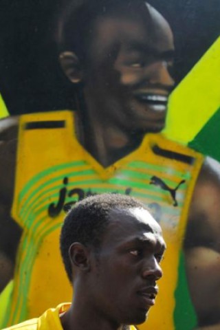 Usain Bolt vor einem Stück der Berliner Mauer, das ihm als Geschenk überreicht wurde.