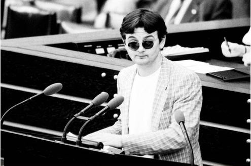 Joschka Fischer provoziert damals die Politiker mit unkonventionellen Aktionen. So trägt er während seiner Reden Sonnenbrille oder auch Turnschuhe.