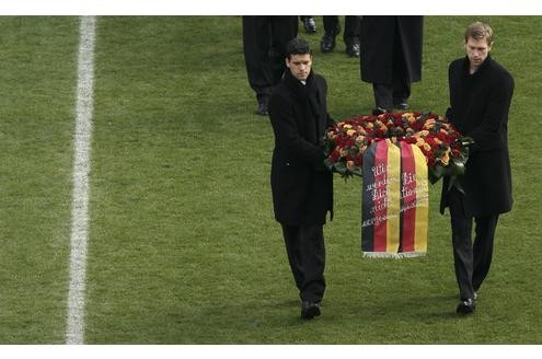 Die deutschen Nationalspieler Michael Ballack (l.) und Per Mertesacker tragen einen Kranz zum aufgebahrten Sarg.