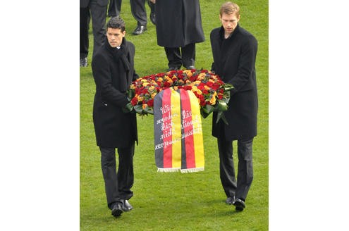 Die deutschen Nationalspieler Michael Ballack (l.) und Per Mertesacker tragen einen Kranz zum aufgebahrten Sarg.