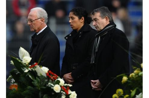 Franz Beckenbauer, Steffi Jones and Wolfgang Niersbach halten inne, um Robert Enke die letzte Ehre zu erweisen.