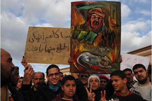 Demonstrierende Menschen mit Anti-Gaddafi-Plakat auf dem ehemaligen Königsplatz von Tobruk