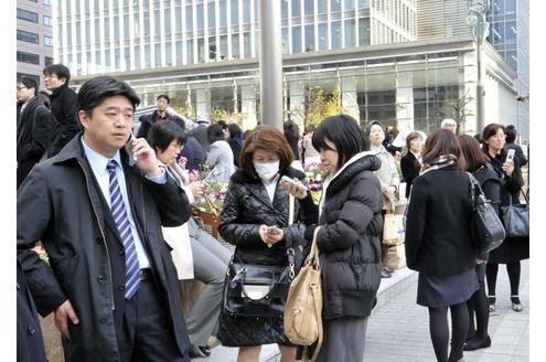 ...Menschen stehen in Tokio auf der Straße. Das Beben der Stärke 8,9 ließ Gebäude in der japanischen Hauptstadt wackeln und setzte andere in Brand...