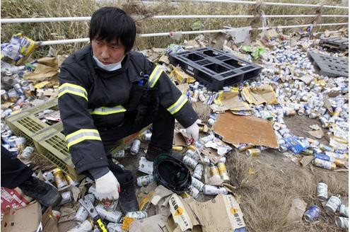 Ein Rettungshelfer aus Südkorea in den Überresten des Großeinsatzes. Die Bierbüchsen sind leer, alle anderen schon wieder unterwegs.
