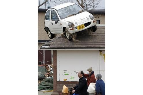 Zu anderen Zeiten ergäbe ein Anblick wie dieser viel Gesprächsstoff. Doch ein Auto auf dem Dach interessiert die Helfer in Sendai nicht im geringsten.