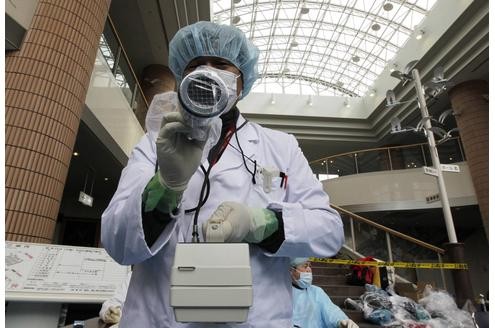 Mittwoch: Ein Fotograf wird im Gesundheitscenter in Niigata im Norden Japans mit dem Geigerzähler gescannt.