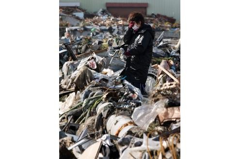 Eine Frau vor den Trümmern ihres Lebens in Sendai.