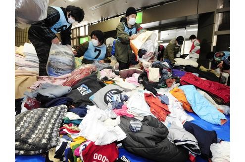 Freiwillige sortieren gespendete Kleidung für Erdbeben-Opfer aus dem Nordosten Japans.