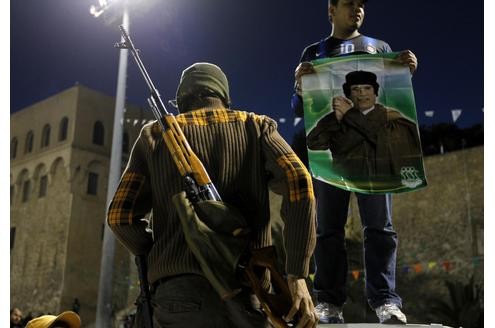 Viele der Demonstranten halten Fotos vom libyschen Diktator in die Höhe.