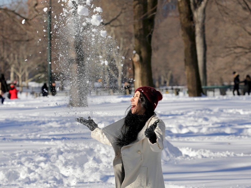 epa05123754 A woman enjoys the snow in Central Park in New York, New York, USA, 24 January 2016. The East Coast of the US is beginning to recover from a major blizzard that dumped near-record amounts of snow in the region. EPA/PETER FOLEY +++(c) dpa - Bildfunk+++