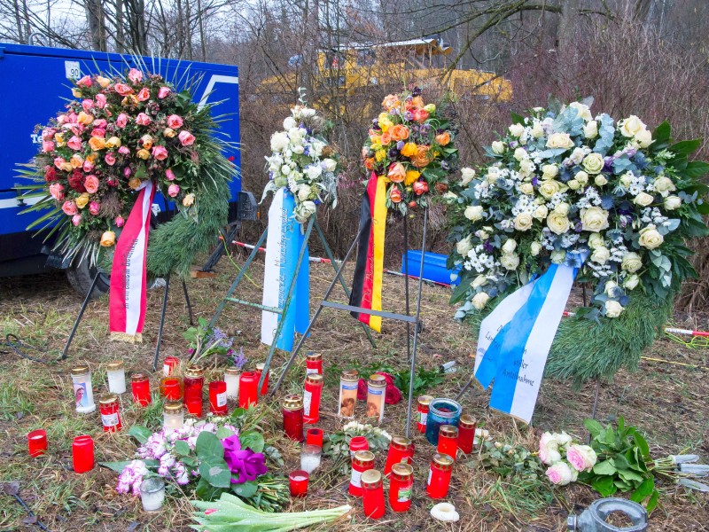 Kränze, Kerzen und Blumen liegen nahe der Unglücksstelle neben den Gleisen. 