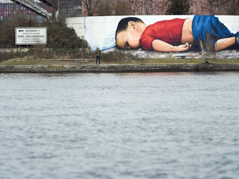 Ein solches Bild war auch 2015 das Foto der Leiche des kleinen Aylan Kurdi, der auf der Flucht seiner Familie nach Europa ertrank. Seine Leiche war an der türkischen Küste angespült worden. Künstler machten aus dem Foto in Frankfurt ein rund 120 Quadratmeter großes Graffiti. 
