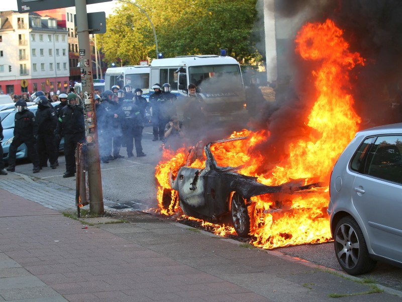 Am Rande der Demo wurden Autos in Brand gesetzt.