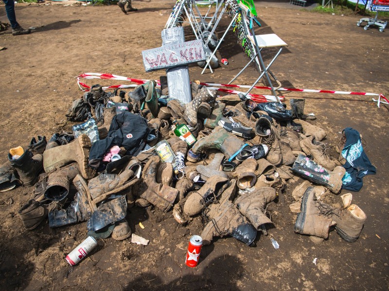 Einige Musik-Fans haben am Samstag auf dem Festivalgelände ihre kaputten und verschlammten Schuhe auf einen Haufen geworfen. 