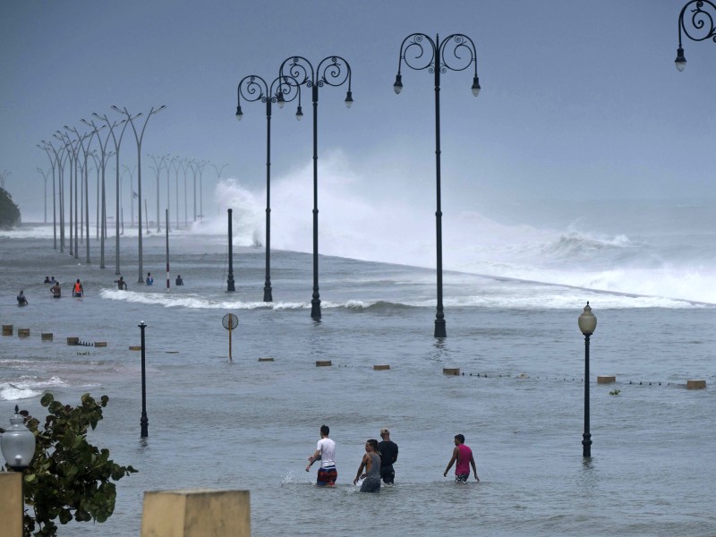 Menschen wateten auch n Havanna (Kuba) über die überflutete Meerespromenade. 