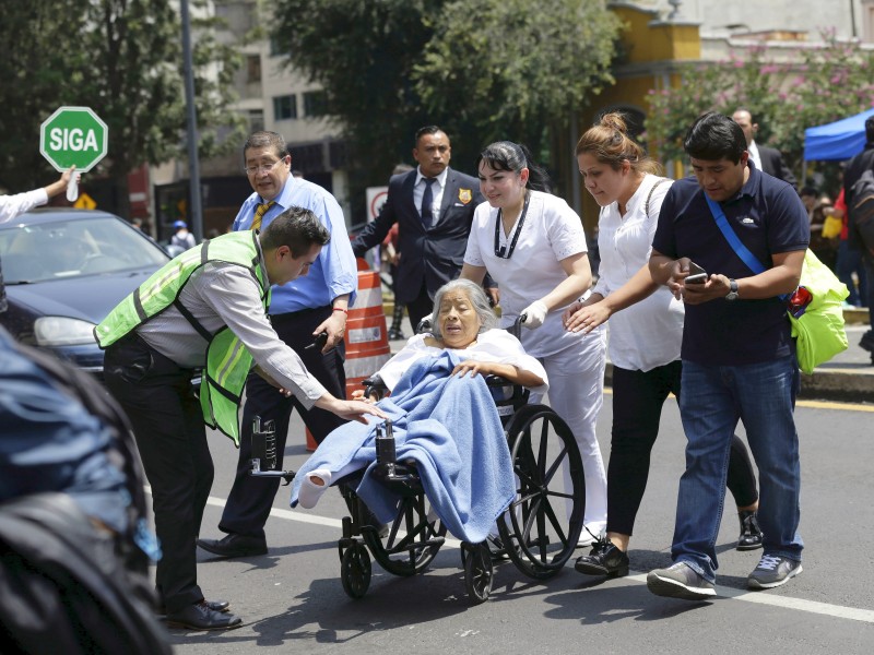 Eine Frau im Rollstuhl wird nach dem Erdbeben bei der Evakuierung einer Klinik in Sicherheit gebracht. 