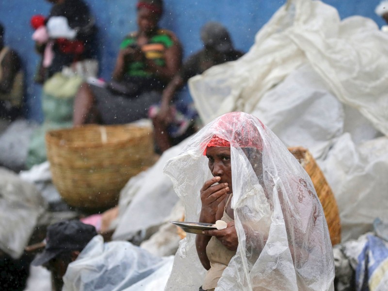 Nur eine Plastikfolie schützt diese Haitianerin vor Wind und Regen. 
