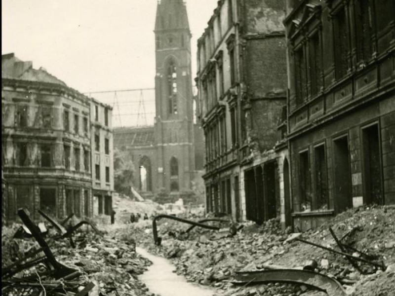 Der Eingang vom Wall ins Klinikviertel 1945. Außerhalb des Bildes links von den Trümmern steht heute der Bergmann-Kiosk am Wall.