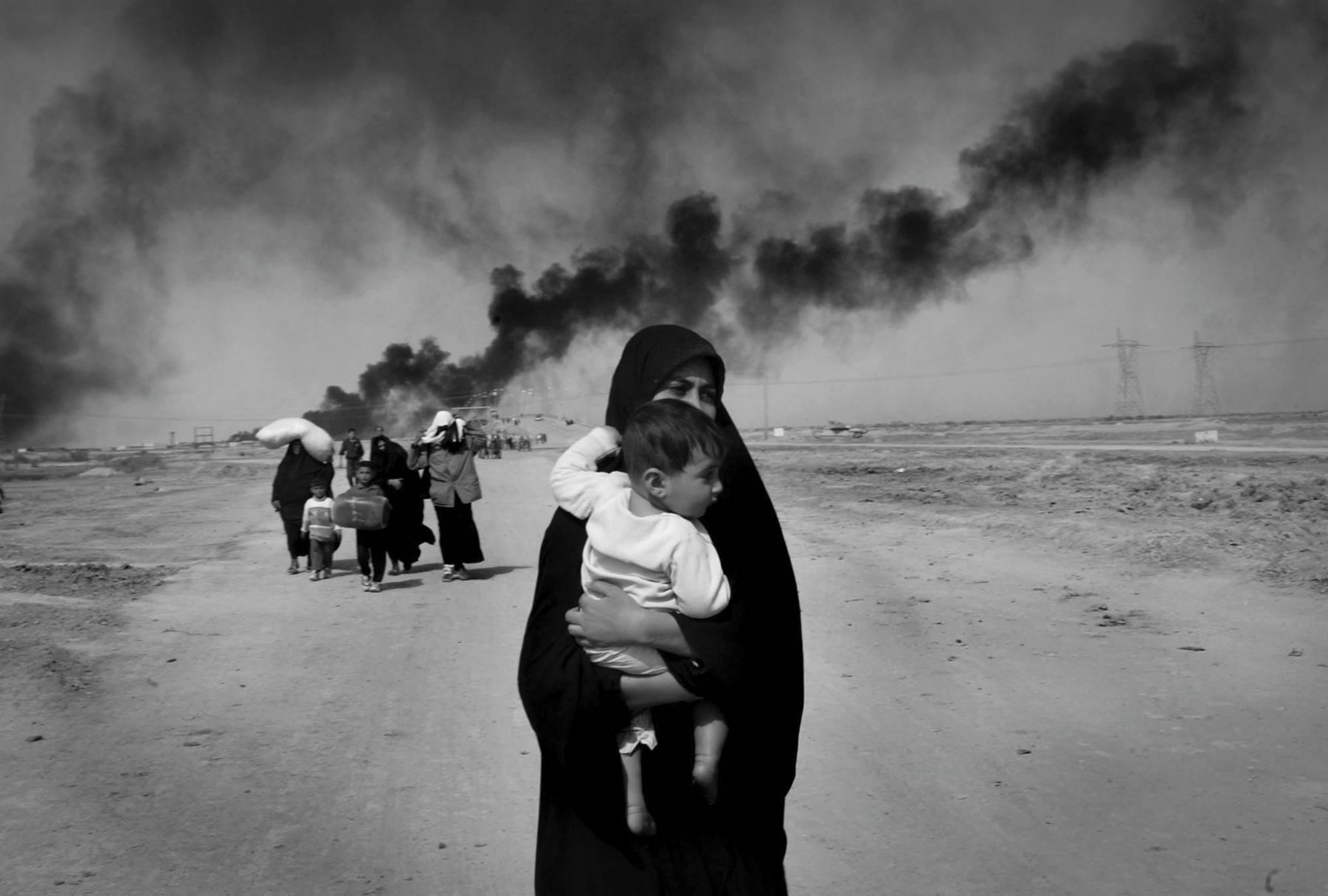 Eine Frau flüchtet mit ihrem Kind aus der irakischen Stadt Basra.