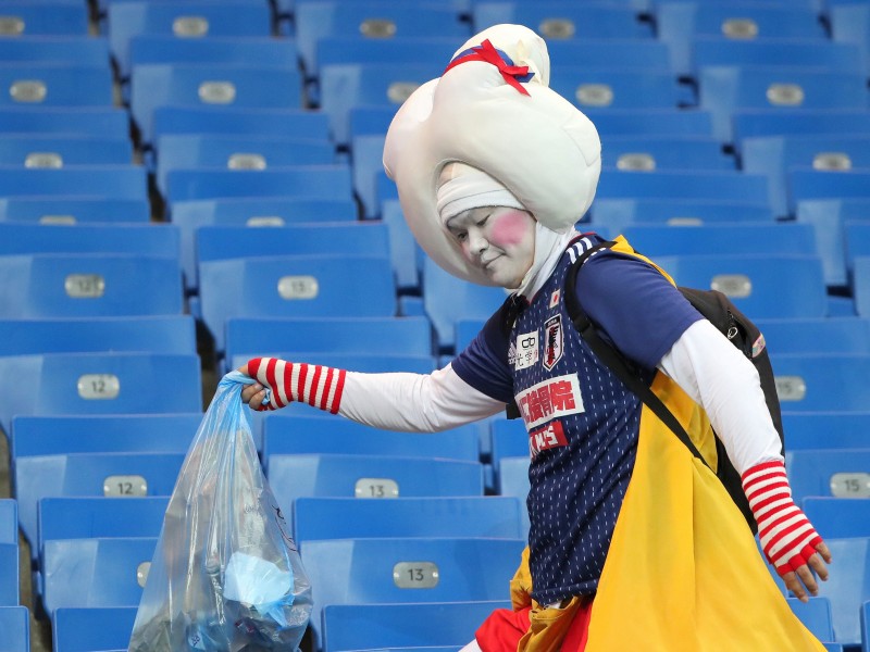 Ehrenwert: Trotz der Niederlage sammeln lustig verkleidete japanische Fans Müll von den Tribünen der Rostow-Arena ein. 