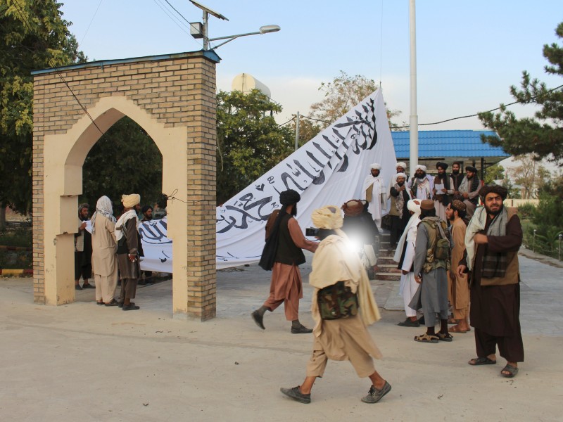 Taliban-Kämpfer hissen eine Fahne vor dem Haus des Gouverneurs der Provinz Ghazni in Afghanistan.