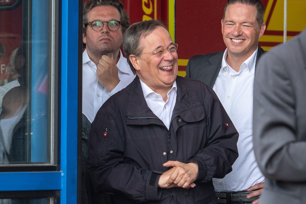 Ein Bild, das ihm viel Kritik einbrachte: Laschet (Mitte) lacht, während Bundespräsident Steinmeier (nicht im Bild) über die Flutkatastrophe spricht.