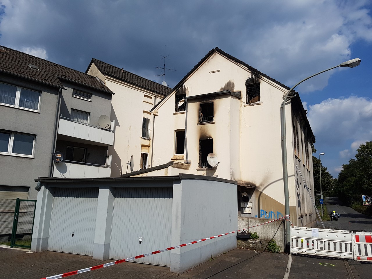 Das Brandhaus am Nachmittag nach dem Feuer: Mahmuts Familie sprang aus dem linken Fenster der Dachgeschoss-Wohnung auf das Vordach der ersten Etage.