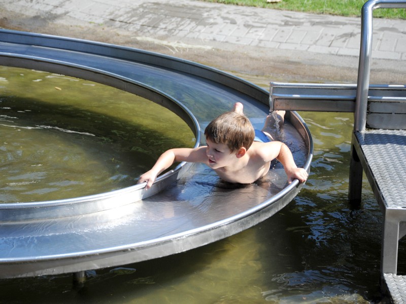 Eine nasse Rutschpartie lockt Familien mit Kinder in den Bürgerpark in Essen.