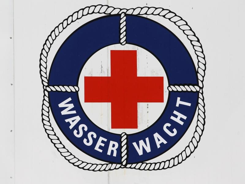 Das Logo der Wasserwacht des DRK an einem Rettungsturm im Ostseebad Warnemünde. Bis September halten die Rettungsschwimmer an bis zu zwölf Türmen Wache.