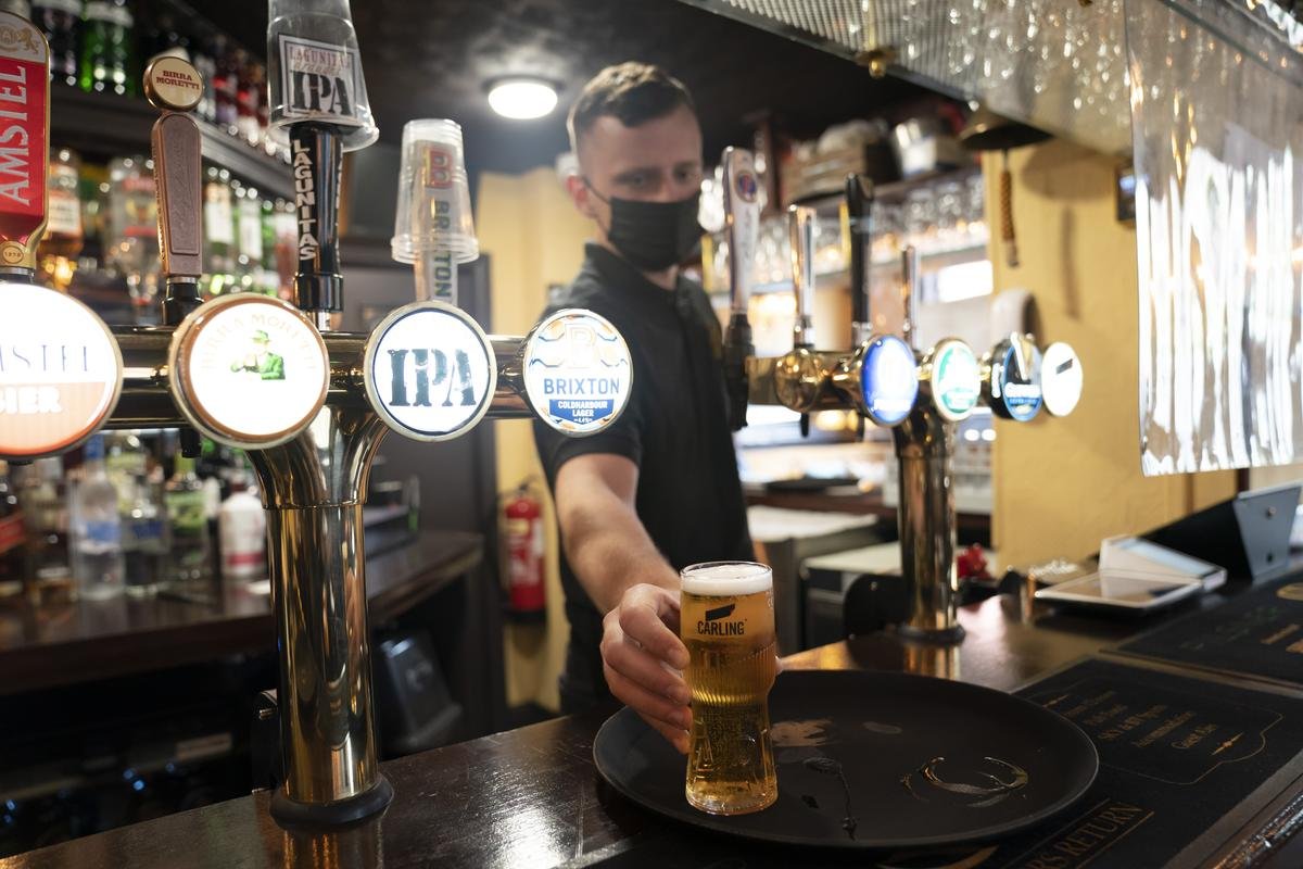 Ein Mitarbeiter eines Pubs serviert ein Bier. Trotz weitreichender Lockerungen von Corona-Regeln haben britische Pubs erneut deutlich weniger Bier verkauft als vor der Pandemie. (zu dpa «Britische Pubs verkaufen deutlich weniger Bier als vor der Pandemie») Foto: Jon Super/AP/dpa