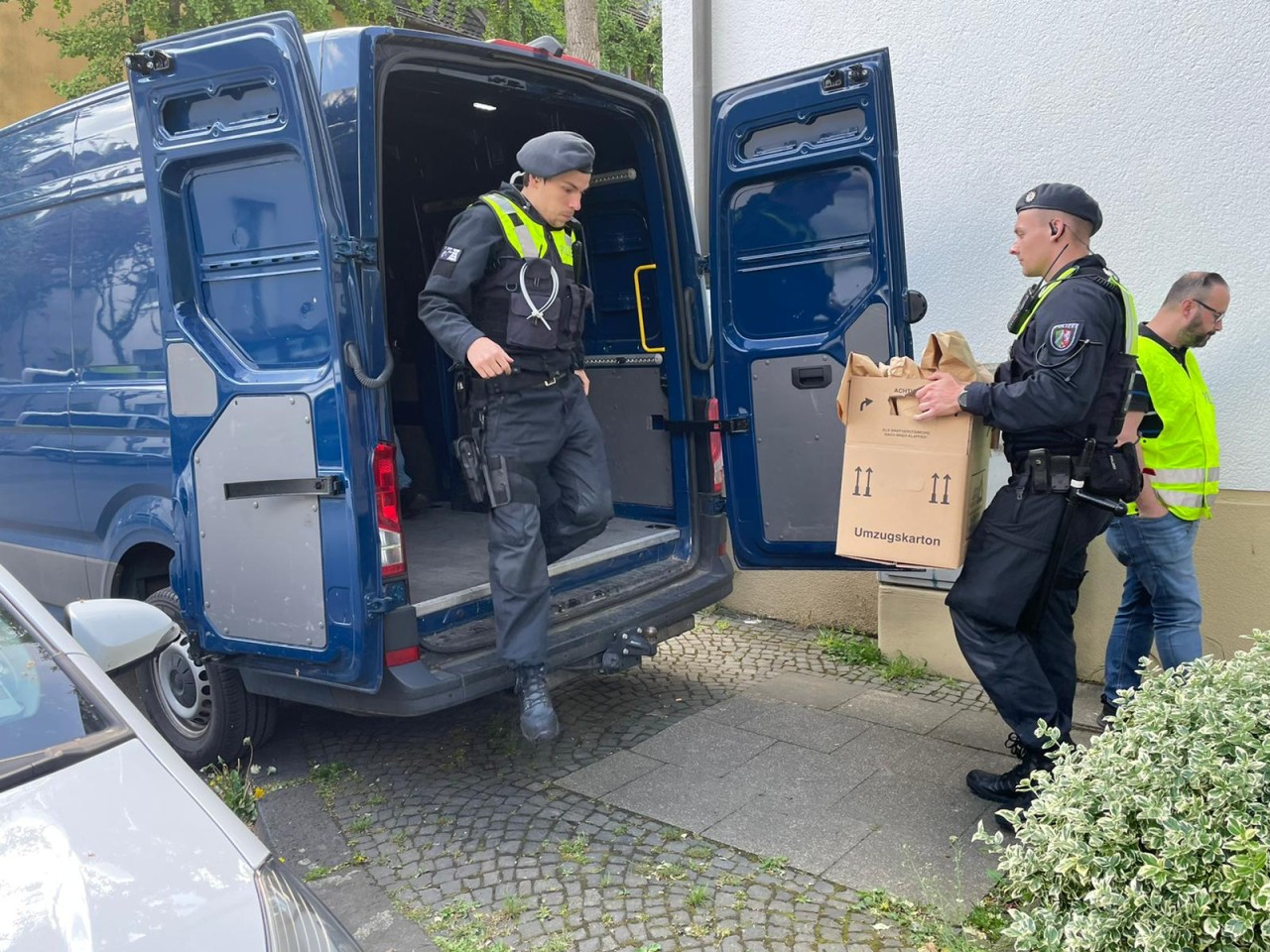 Essen: Polizisten tragen Kartons mit Beweismaterial in einen Transporter.
