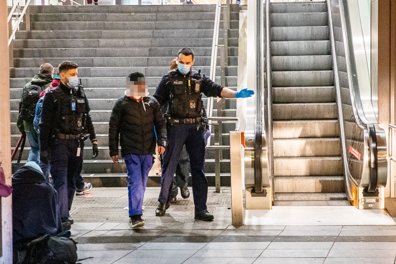 Essen Hauptbahnhof: Bundespolizisten greifen den am Hals verletzten Mann auf, bringen ihn zum Rettungswagen.