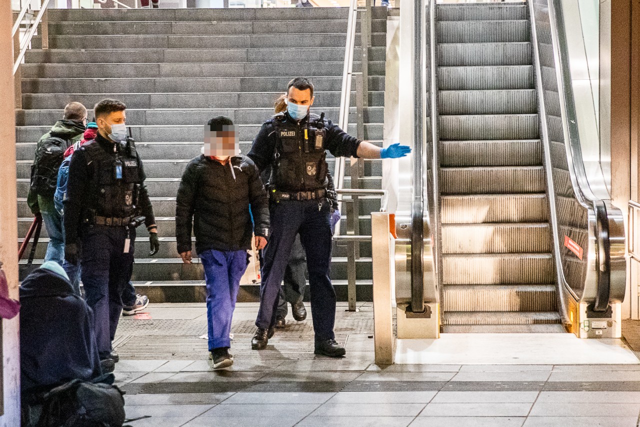 Essen Hauptbahnhof: Bundespolizisten greifen den am Hals verletzten Mann auf, bringen ihn zum Rettungswagen.