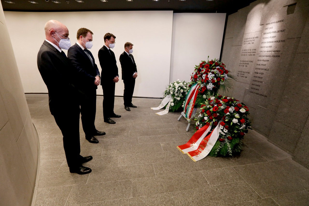 Vertreter des Flughafens gedenken still mit NRW-Verkehrsminister Wüst (2. von rechts) an die Brandkatastrophe von 1996.