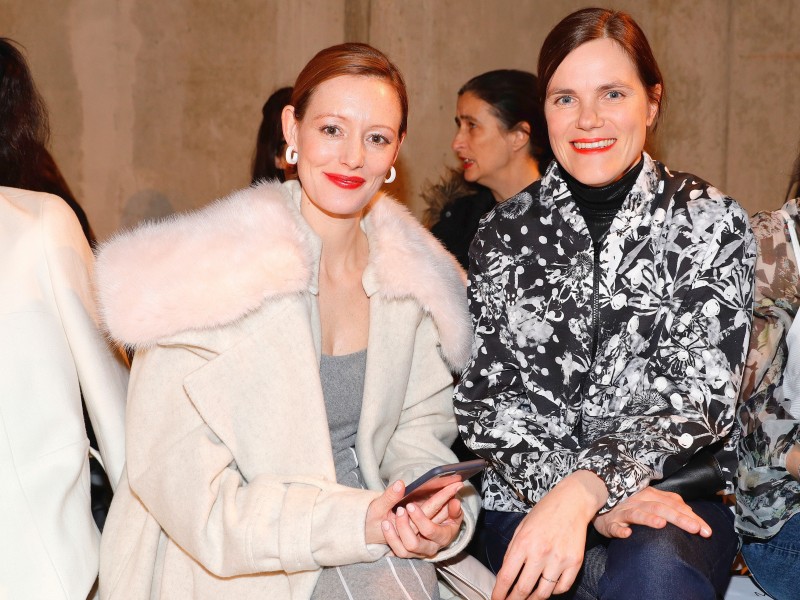 Die Schauspielerinnen Lavinia Wilson (l.) und Fritzi Haberlandt genießen die Show der Berliner Marke Malaikaraiss im Mode Salon im Kronprinzenpalais.