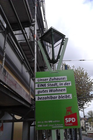 Nicht schlecht, liebe SPD, ihr könnt ja sogar kontextsensitive Plakatierung: Das Plakat zum bezahlbaren Wohnraum hängt an einem Baugerüst in Essen-Rüttenscheid.