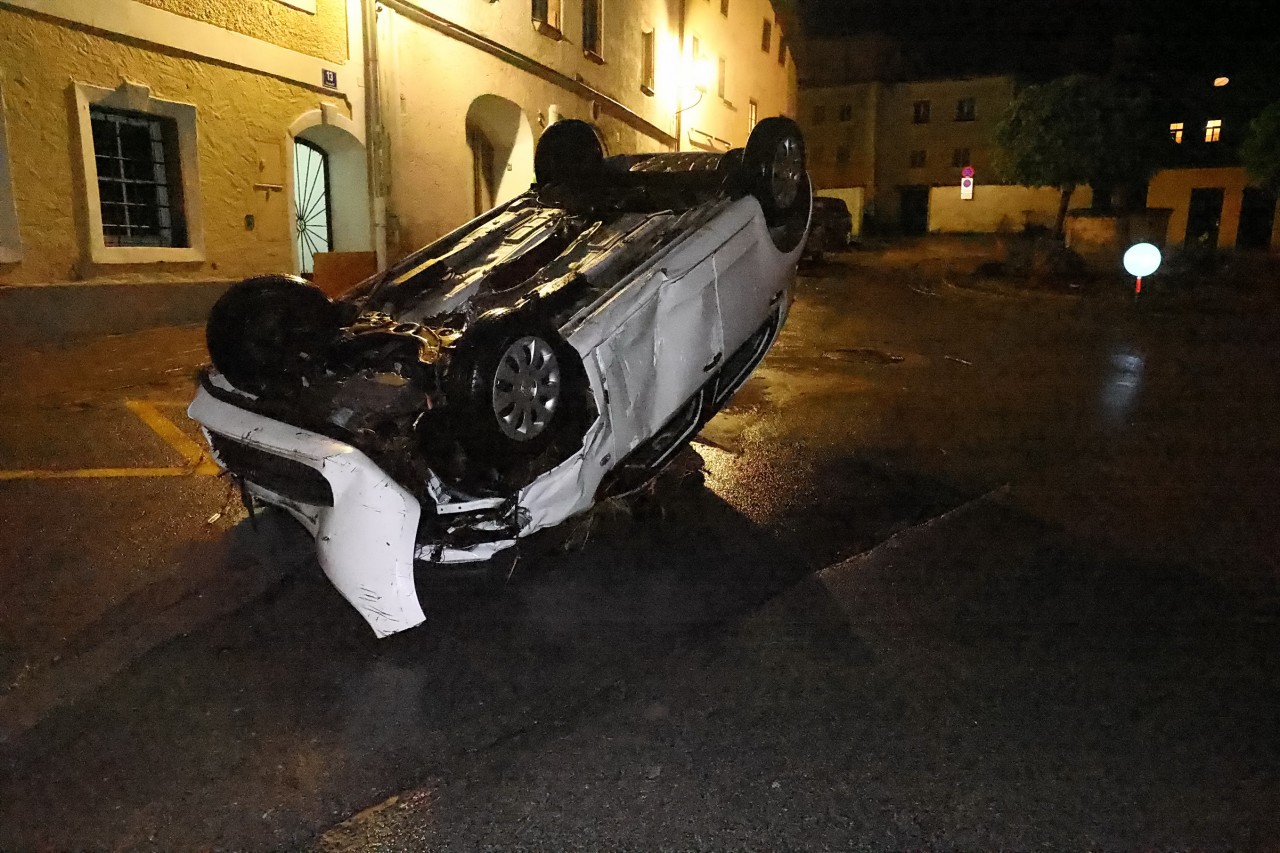 Österreich, Hallein: Ein Auto liegt mit dem Dach auf einer Straße.